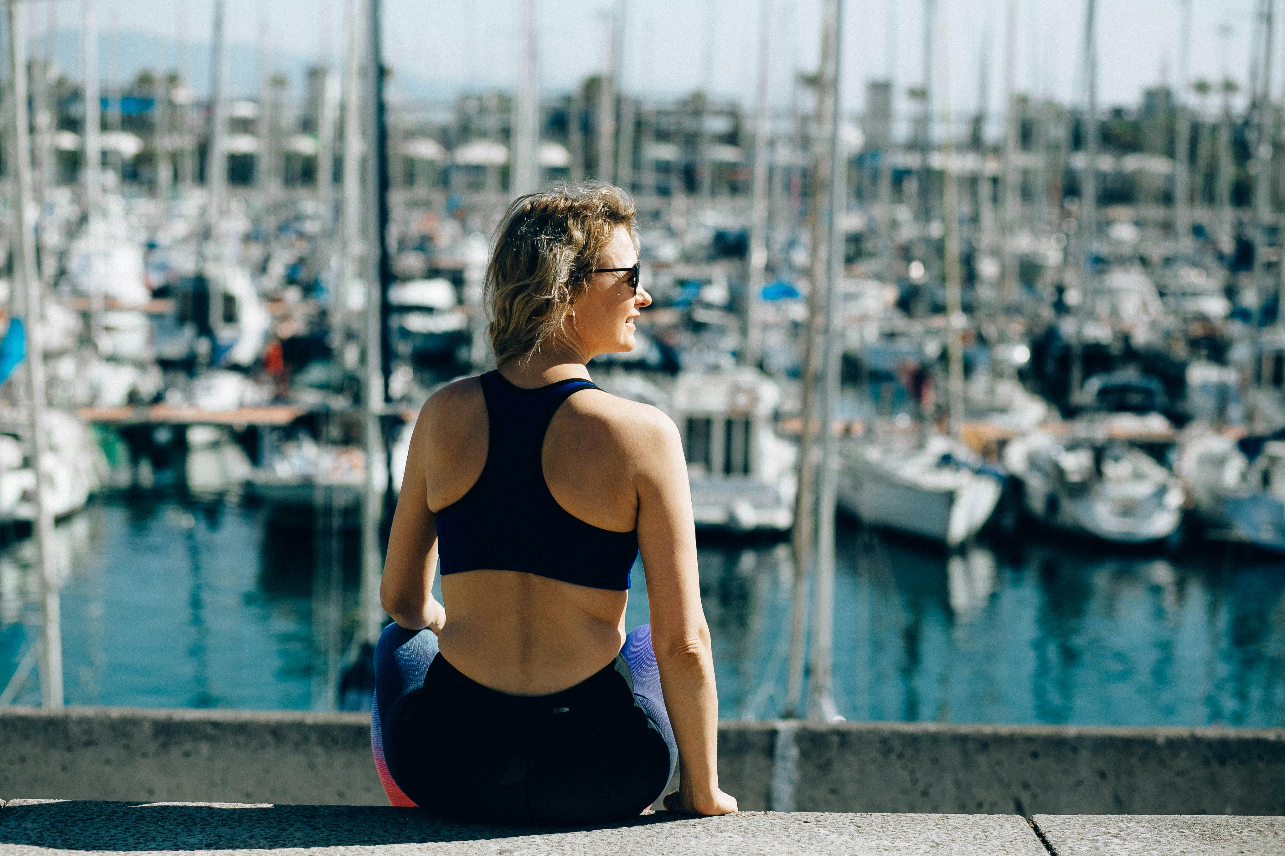 back view of a woman sitting near the harbour