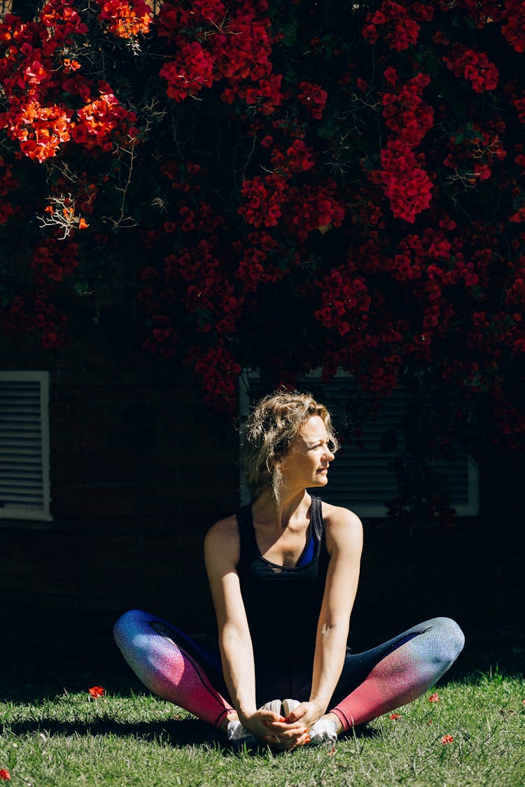 Woman Sitting On Grass While Looking Sideways