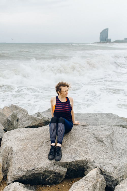 Photo of a Woman Sitting on a Rock