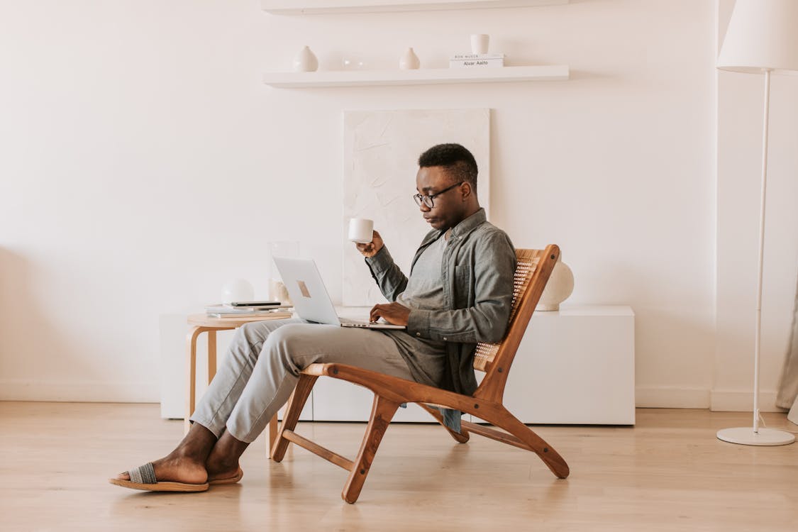 Free Man Sitting With a Laptop on his Lap Stock Photo