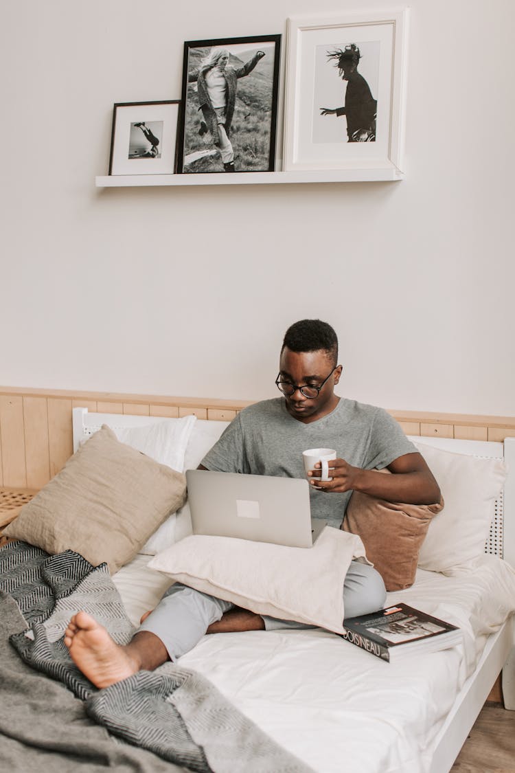 Man Sitting In Bed With His Laptop