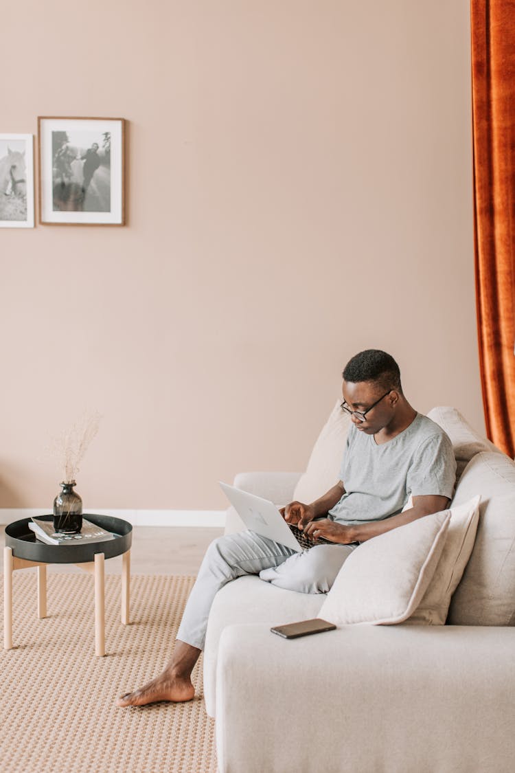 Man In White Robe Sitting On White Couch