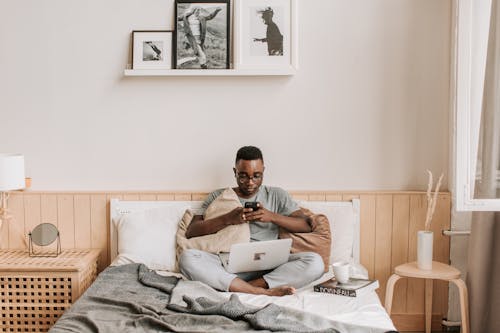 Безкоштовне стокове фото на тему «SMS, афроамериканський чоловік, ліжко» стокове фото