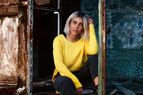 Trendy woman with makeup near rough wall