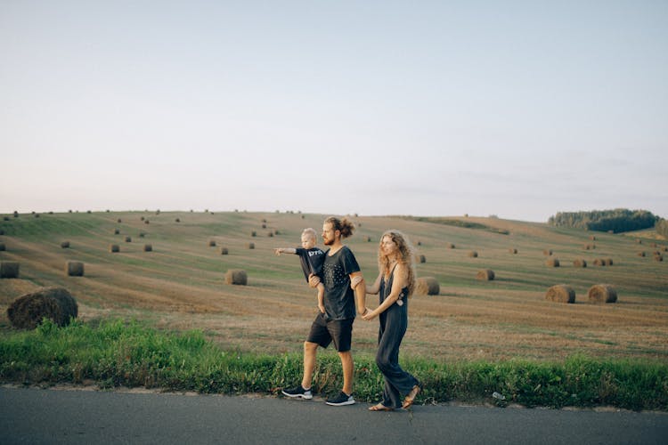 Couple Walking Outdoors With Their Baby