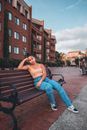 Bored Young Woman Sitting on Bench on Housing Estate