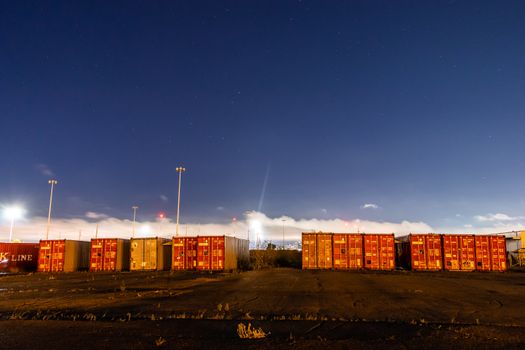 夜空中星光闪烁，映照着工业工地上堆叠的集装箱