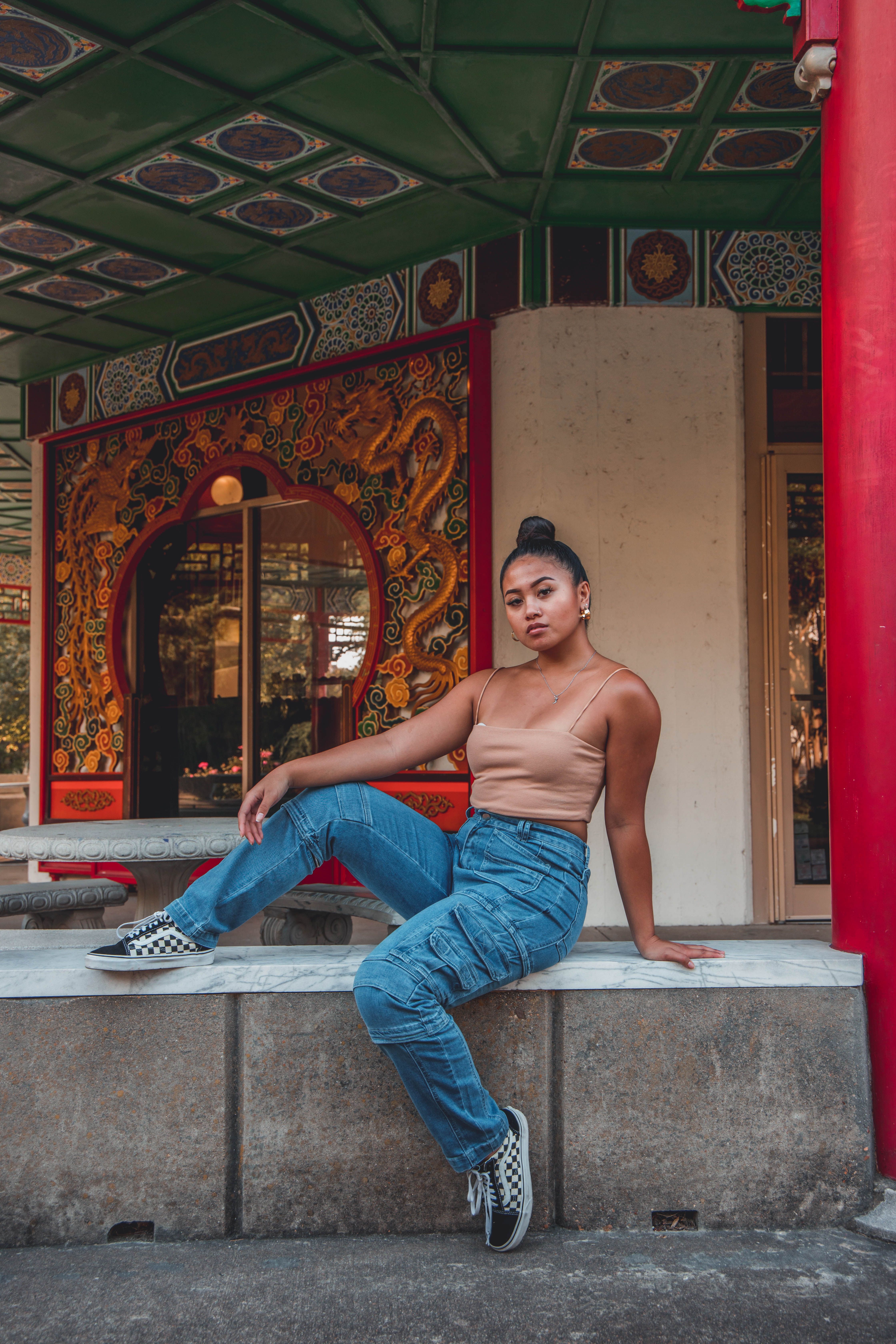 Woman in Denim Jeans Sitting on a Concrete Bench · Free Stock Photo