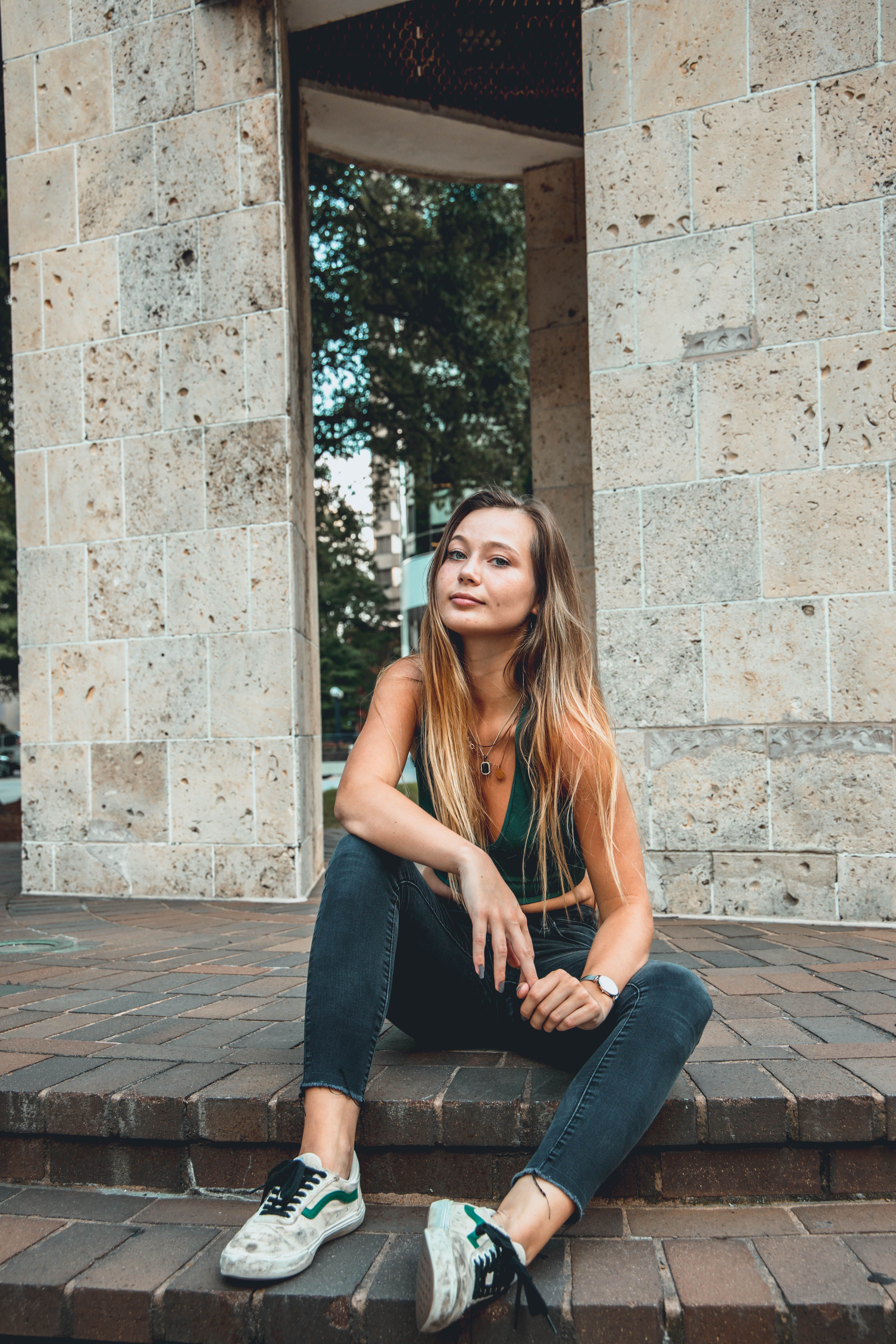 Woman in Tank Top and Jeans Sitting on Brick Steps · Free Stock Photo