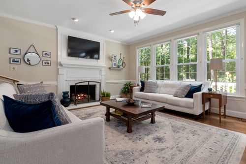 Free Modern living room interior with large windows, fireplace, and comfortable seating. Stock Photo