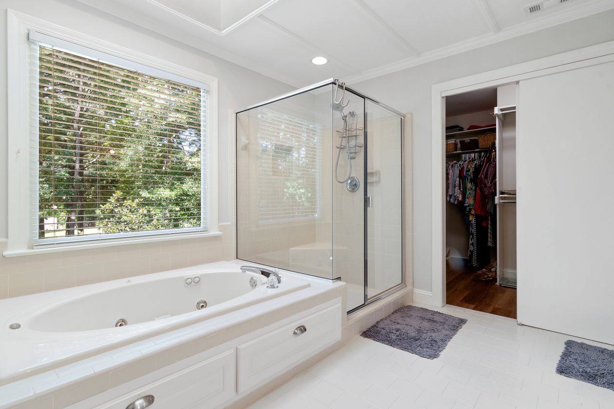 White bathroom with a tub and a glass shower enclosure