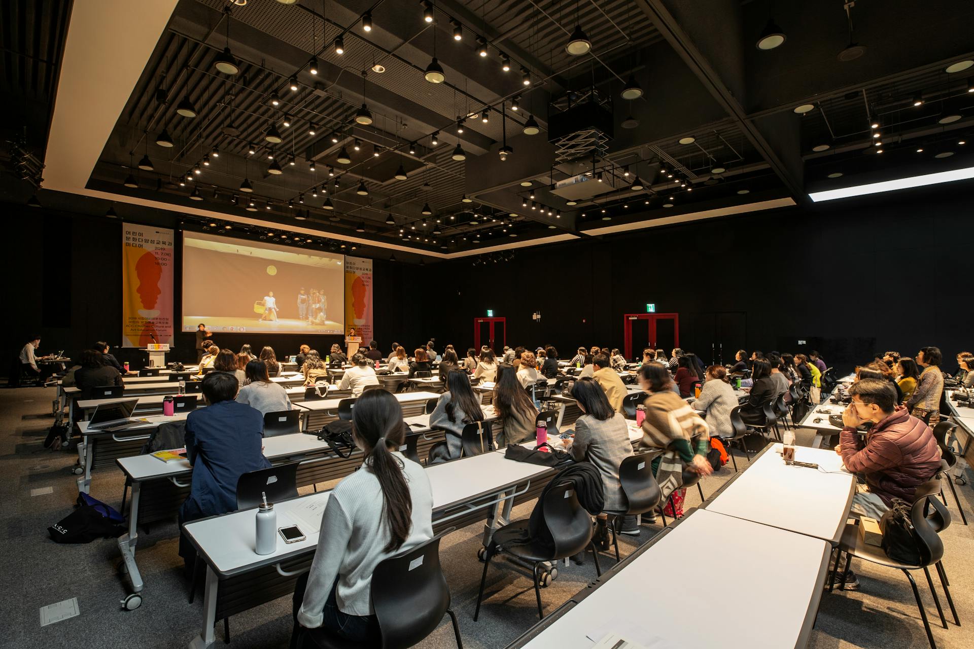 A diverse group attending a conference in a modern hall in Gwangju, South Korea.