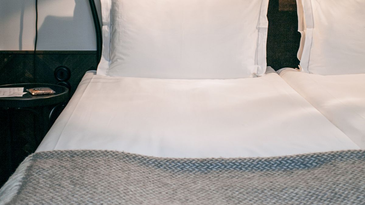 Hotel bed with white linens and soft morning light