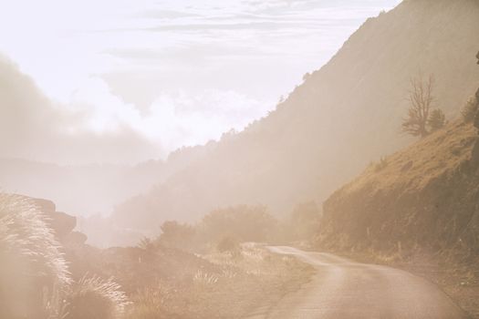 穿越山谷岩石山丘的狭窄乡村公路，在雾天景色壮观