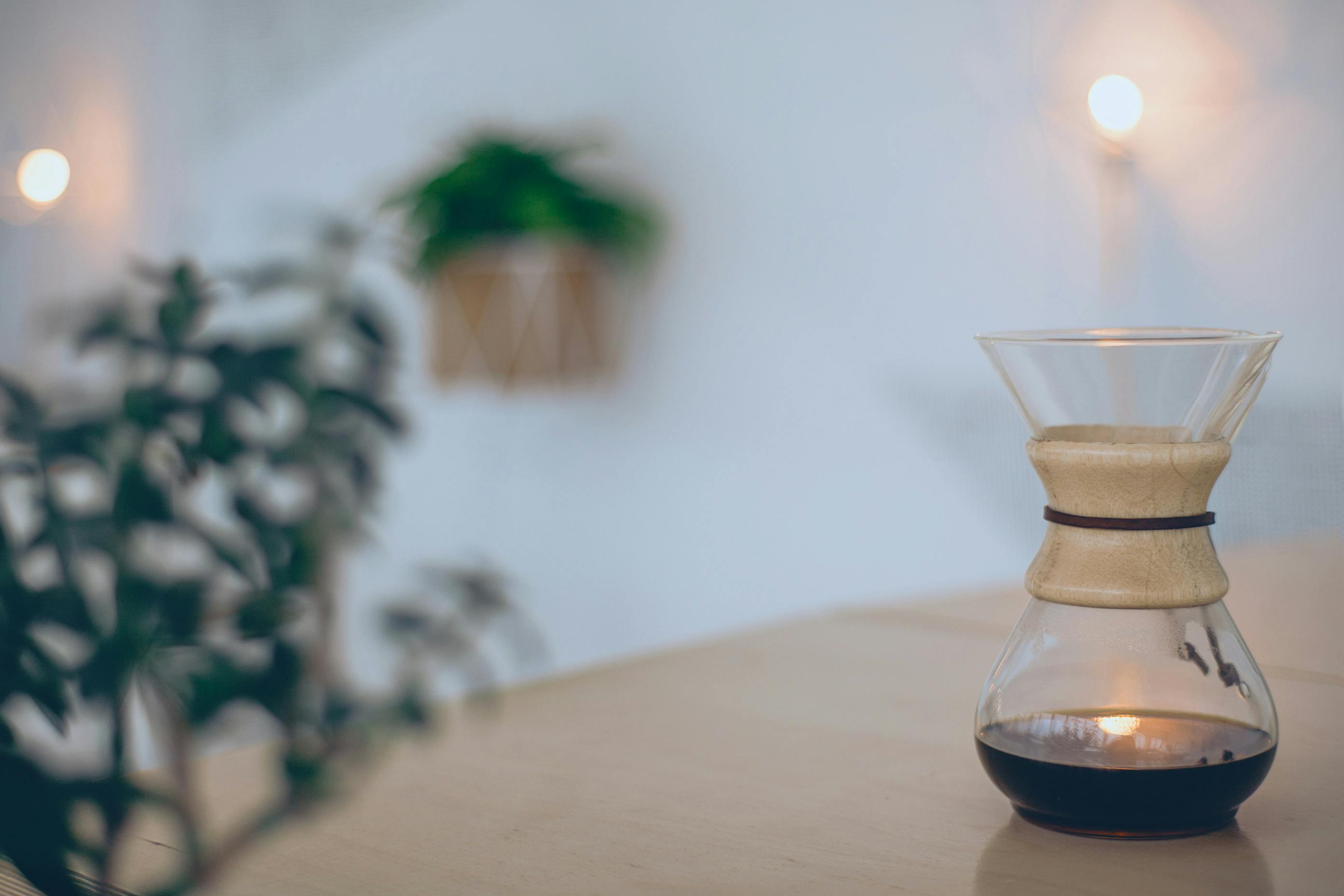 Warm and inviting indoor scene featuring a Chemex coffeemaker with soft lighting.