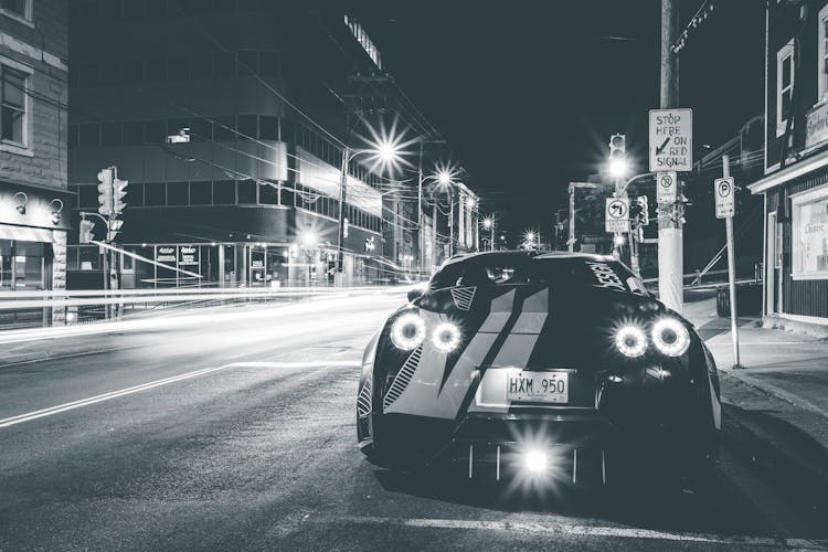 Modern Racing Car On City Road With Shiny Lights