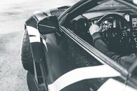 Unrecognizable man driving sports car on road