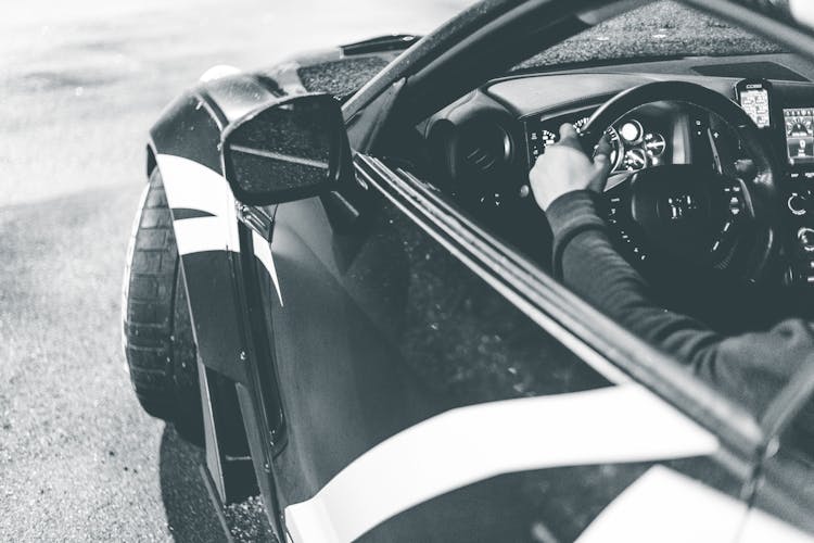 Unrecognizable Man Driving Sports Car On Road