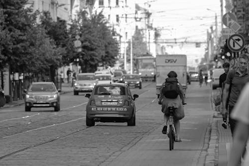 Busy city road with moving cars and pedestrians on sidewalk