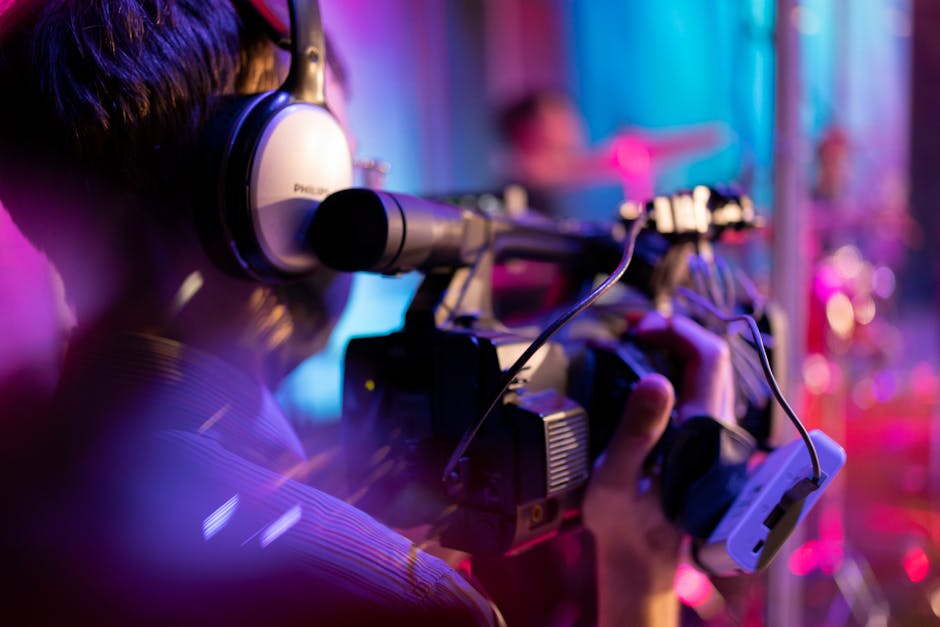 Videographer with headphones filming indoor event