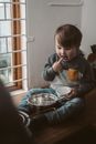 一个年幼的孩子在室内用搅拌器和碗探索烘焙，充满好奇与乐趣