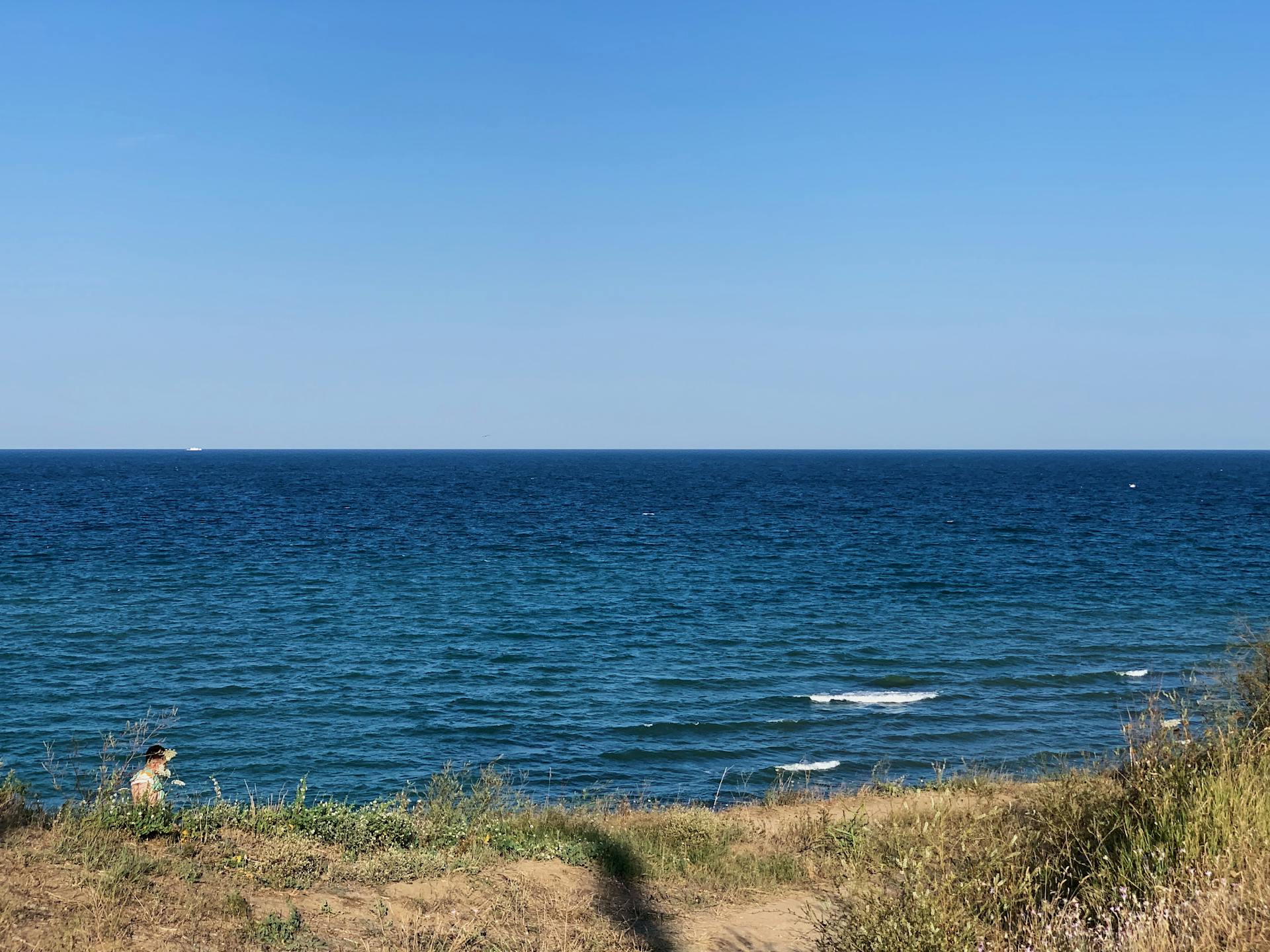 Idyllic view of the serene Black Sea coastline in Schitu, Romania, under a clear blue sky.