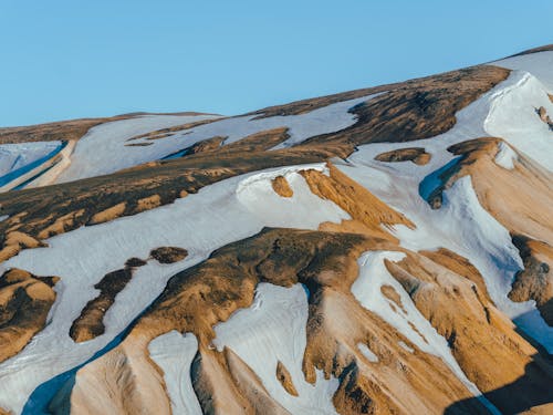 Montaña Marrón Y Blanca Bajo Un Cielo Azul