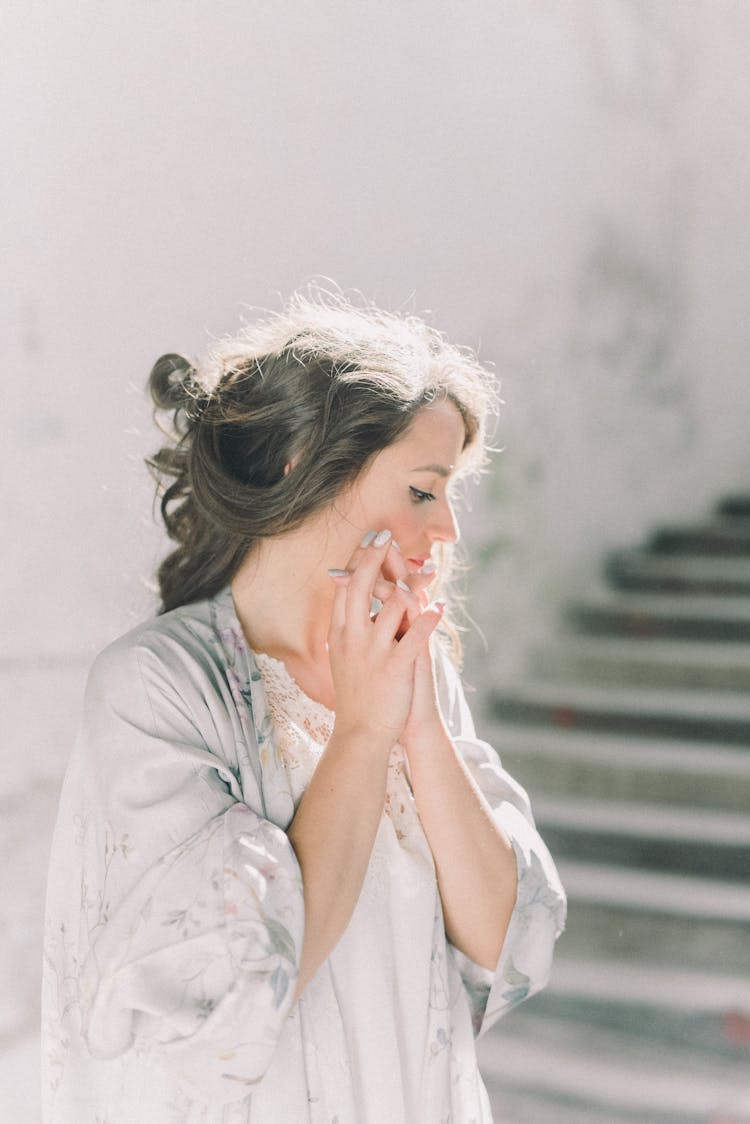 A Woman In Her Robe Clasping Her Hands