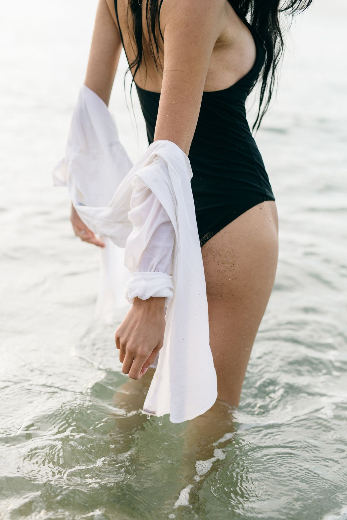 A woman in a black bathing suit — the sculptural one-piece