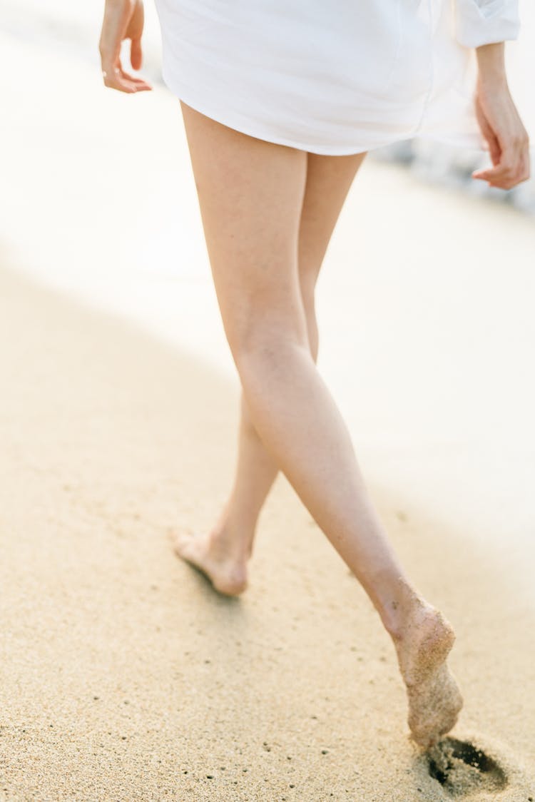 Person Walking Barefoot On Seashore