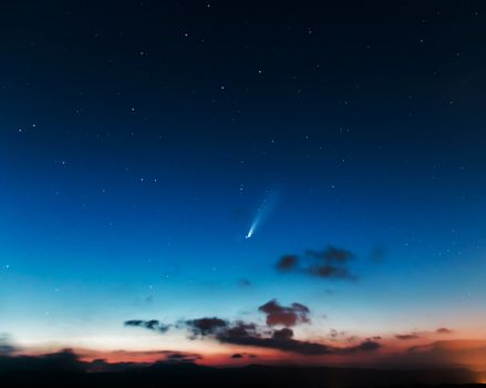 夜空中景色壮观，地平线上有一颗明亮的彗星和众多星星