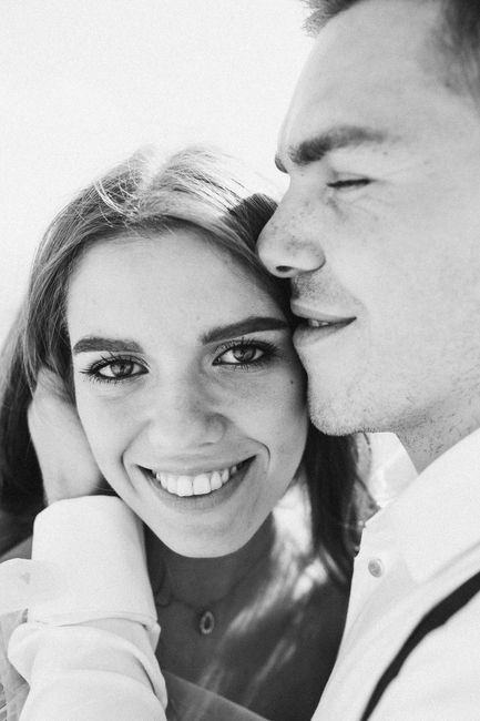 A close-up black and white photo of a happy couple smiling together, showcasing love and happiness.