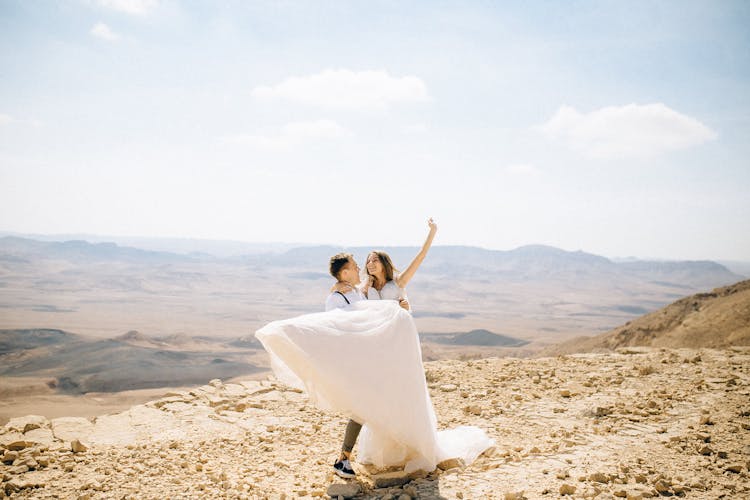 Groom Carrying Bride In The Desert