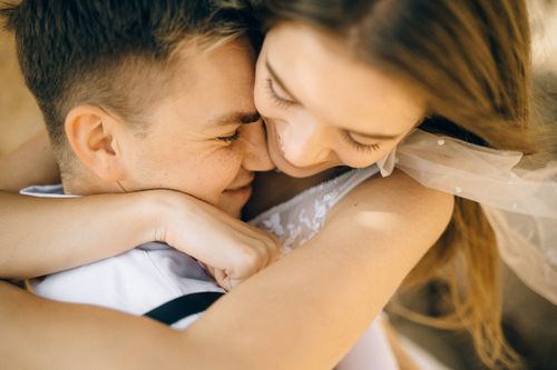 Free Romantic close-up of a joyful newlywed couple embracing and smiling. Stock Photo