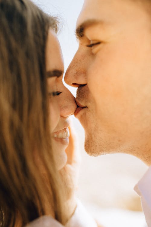 Close Up Photography of Man Kissing Woman Nose