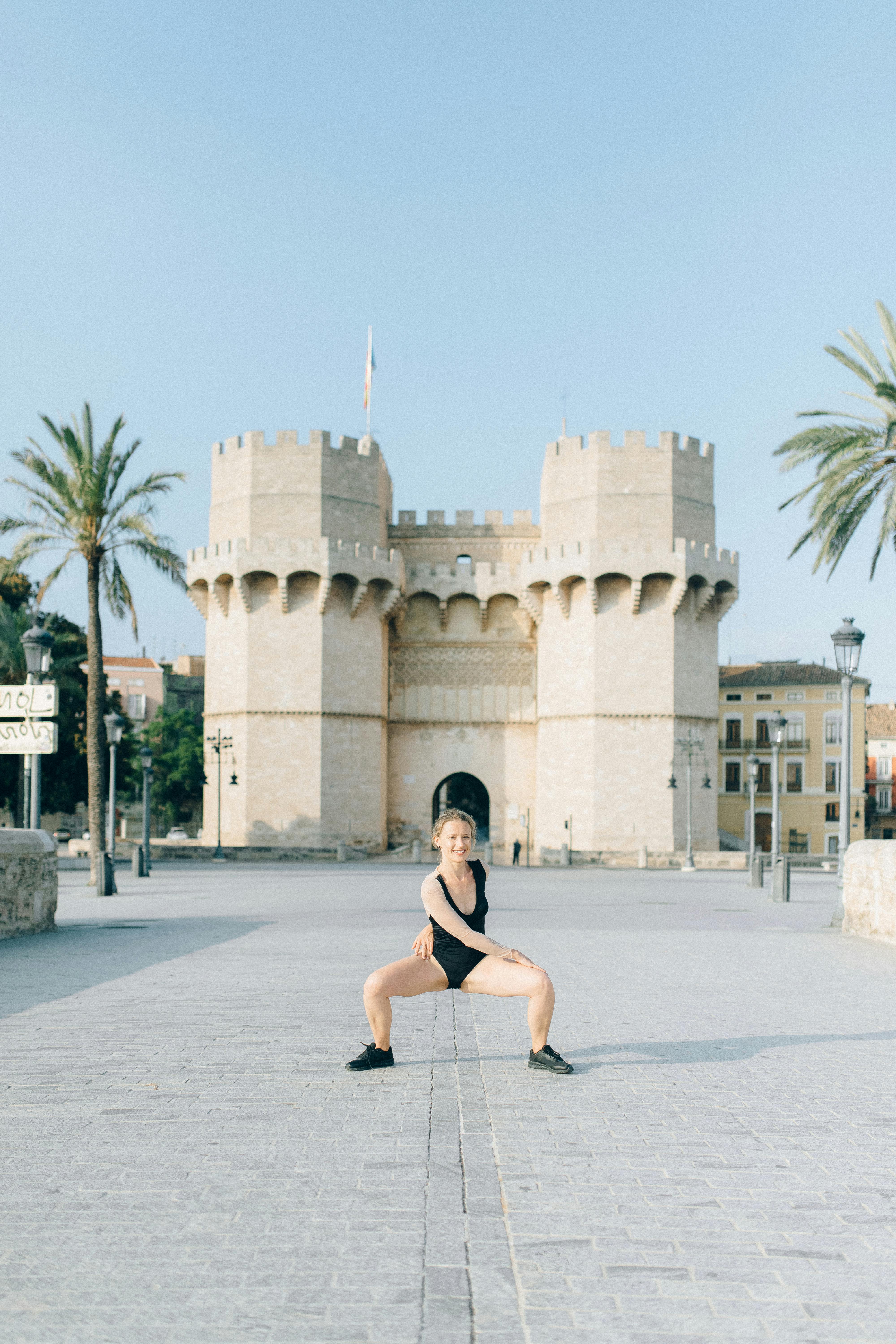 a woman meditating in front of a castle