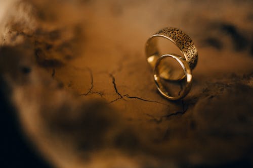 Selective Focus Photo of Two Rings on a Brown Surface