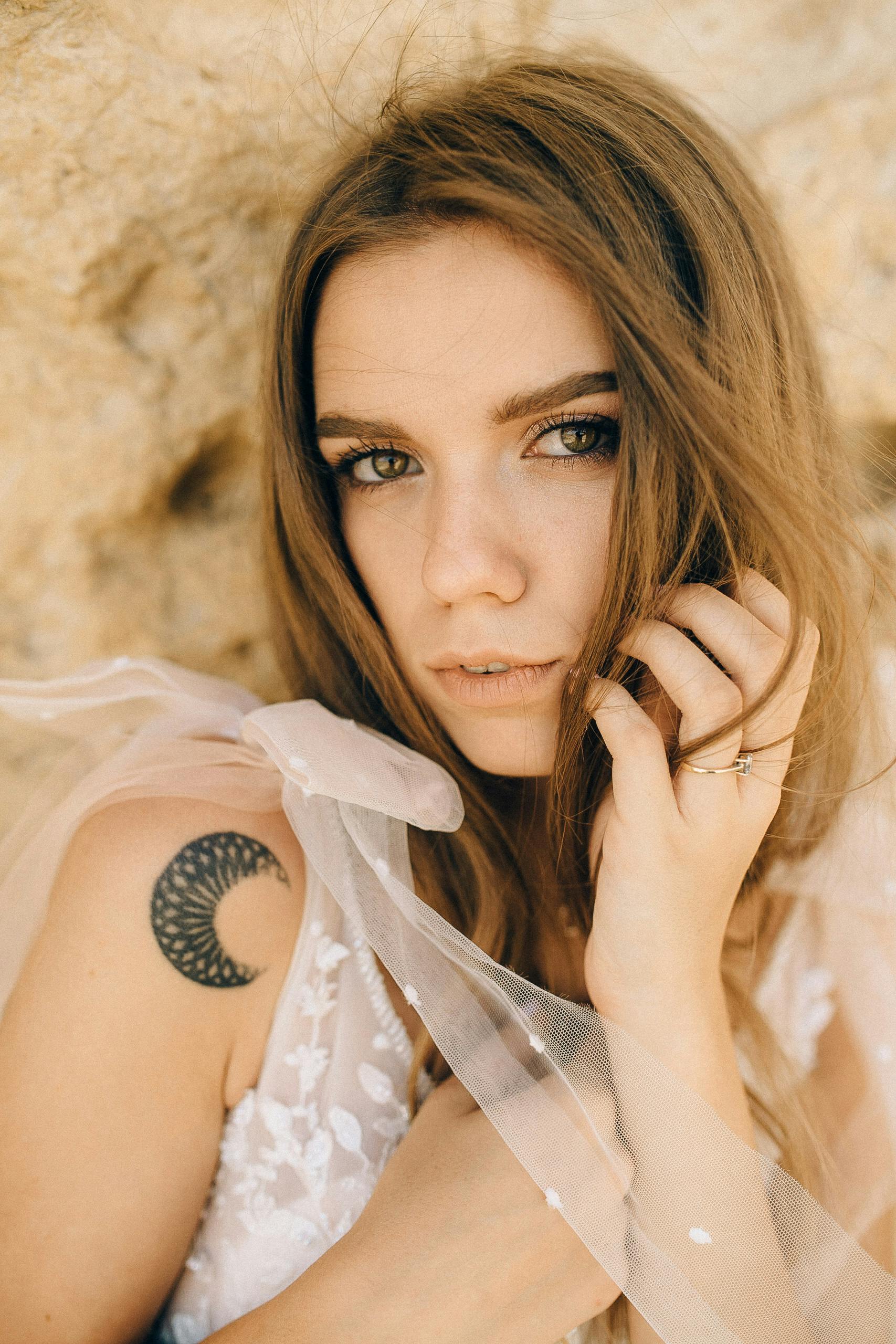 柔和灯光下，一位有月亮纹身的女人的特写肖像