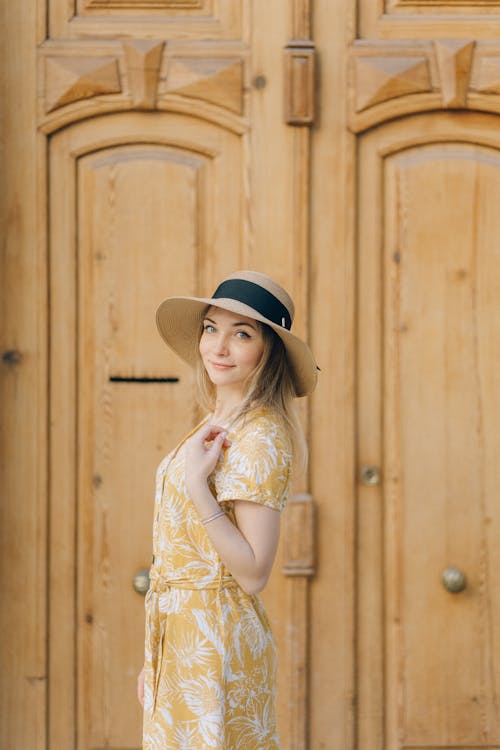 Free Pretty Woman in Yellow Dress and Sun Hat Looking at Camera Stock Photo