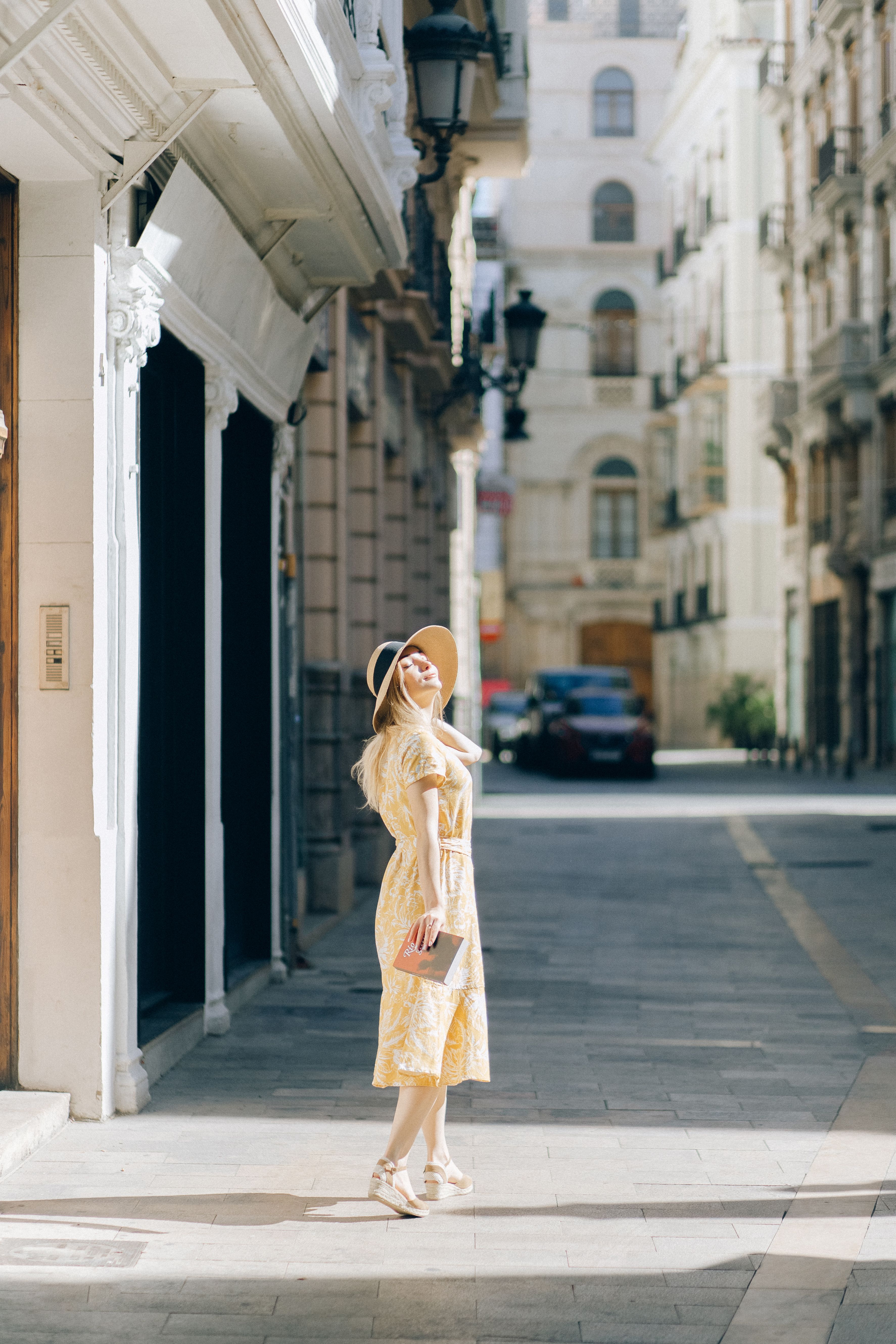 Carefree Woman in Yellow Dress Standing on Pavement · Free Stock Photo
