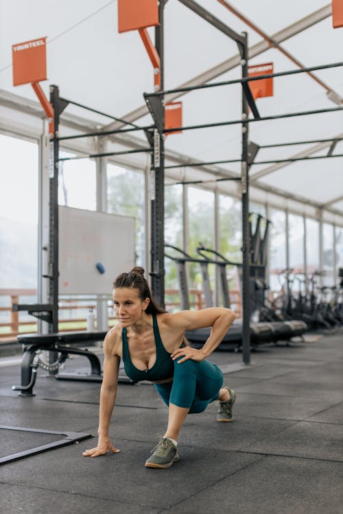 Woman in Black Tank Top Exercising at the Gym