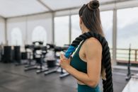 一名女子在健身房里拿着绳索，展示力量和健身能力