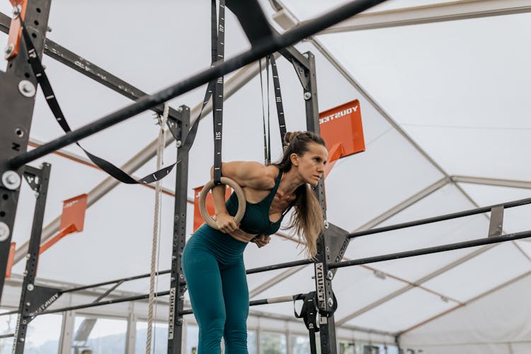 A Masculine Woman Hanging On Rings