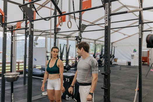 Man and woman exercising at an indoor gym, focused on fitness goals.