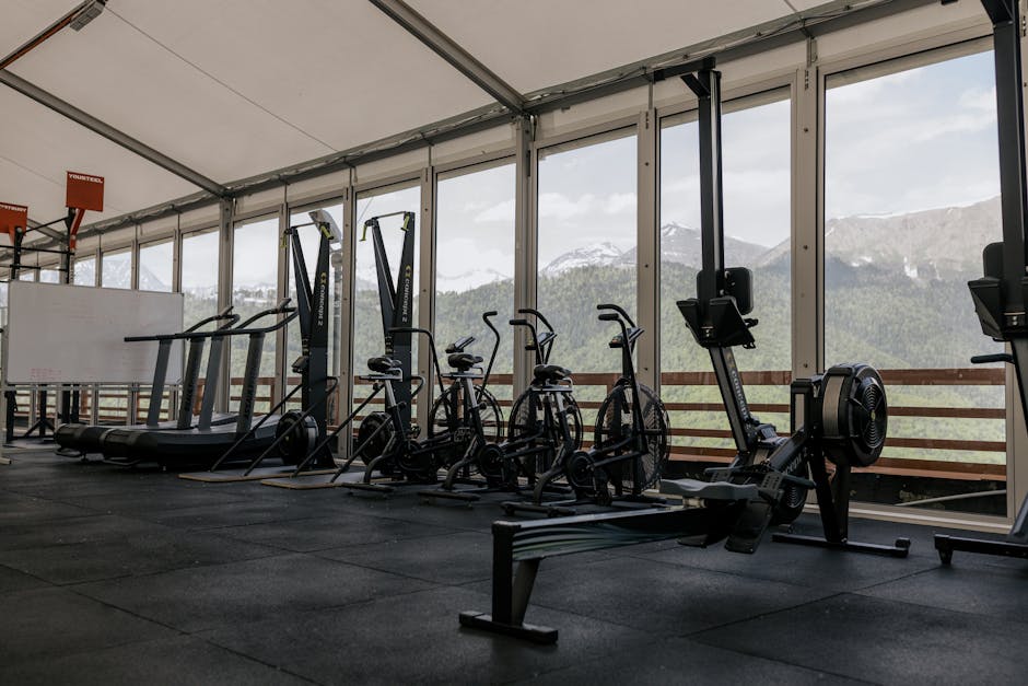 Peloton vs NordicTrack: Home Bike Showdown (2025) Spacious indoor gym featuring state-of-the-art equipment with scenic mountain views outside large windows.