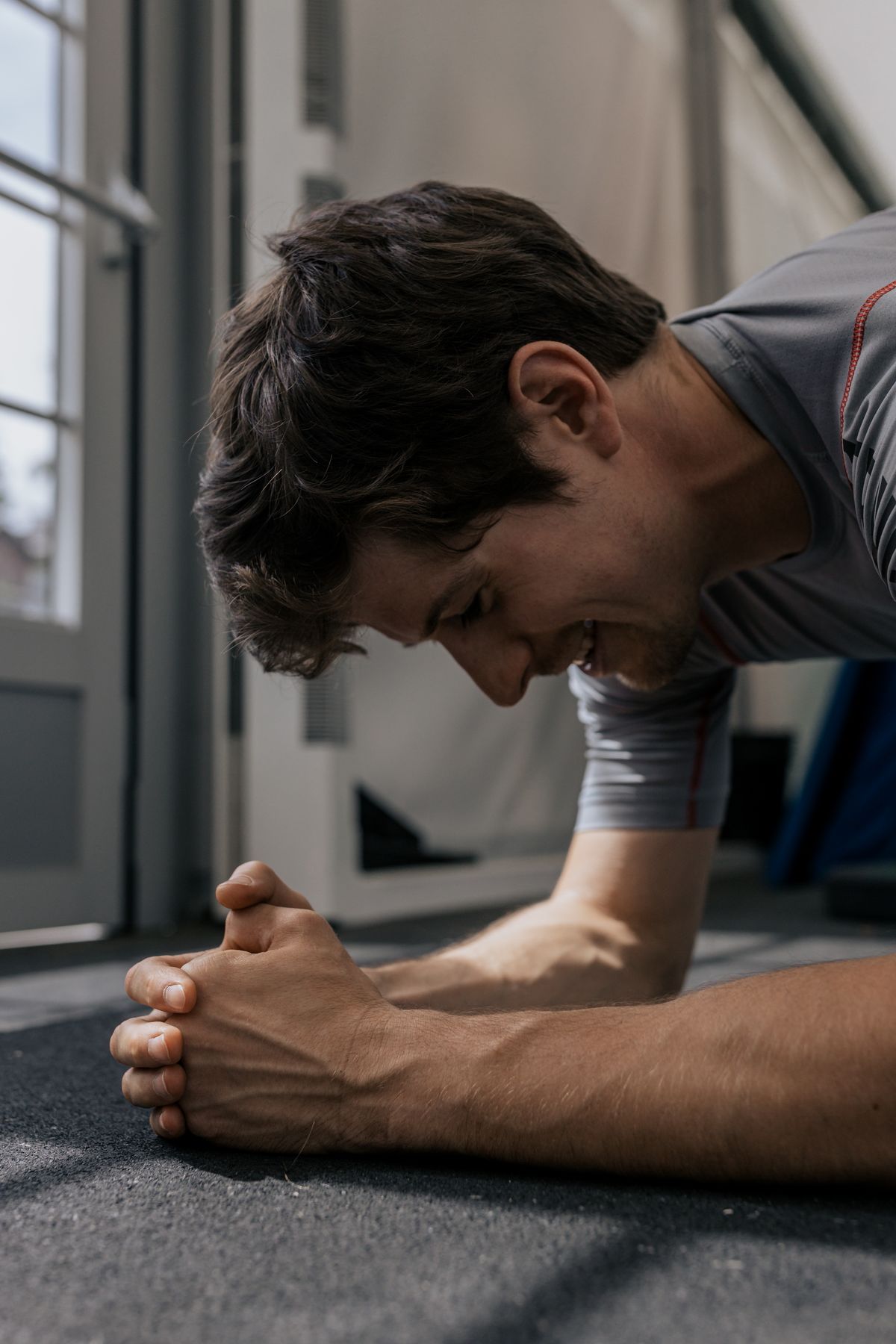 Man performing a plank exercise indoors with concentration
