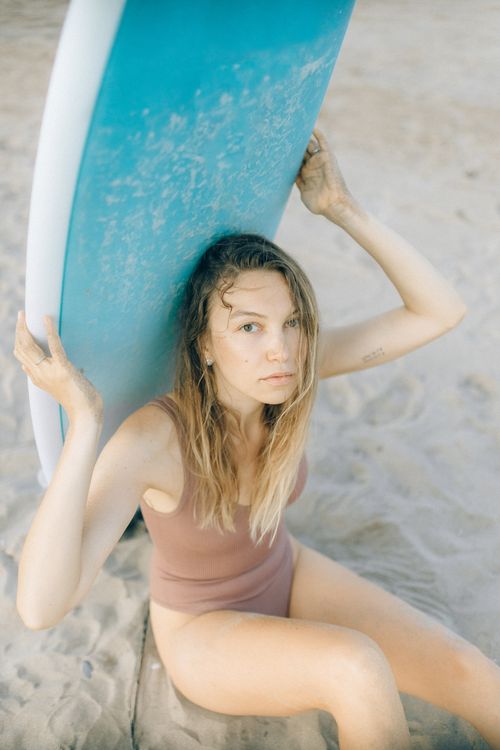 A Woman in Brown Swimwear Sitting on Beach Sand · Free Stock Photo