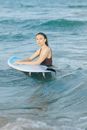 一个女人在清澈的海水中，正享受着冲浪板上的宁静时刻