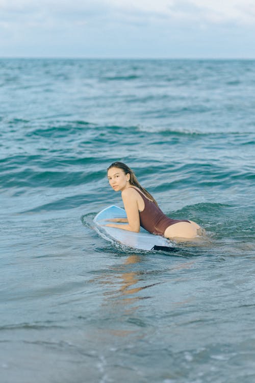 Woman Lying on Surfboard