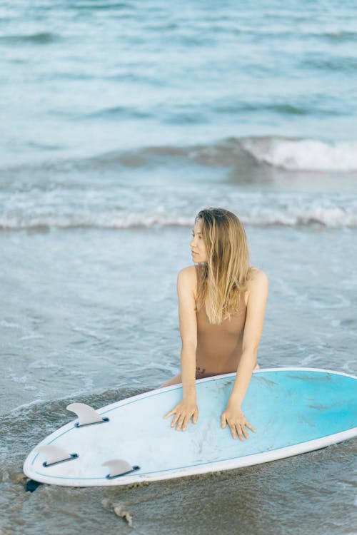 Woman Holding Surfboard While Looking Sideways